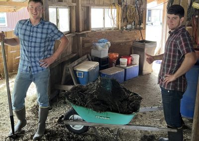 Volunteers cleaning the goat barn